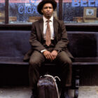 Suited up black man Frank Custer sits on bench