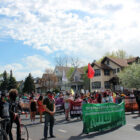 a large crowd of marchers and protestors make their way down the street