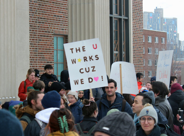 Graduate workers hold up signs in support of a union at the February 20 rally.