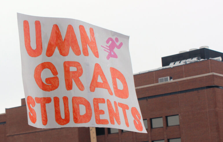 A sign at the February 20 rally reads "UMN runs on grad students".