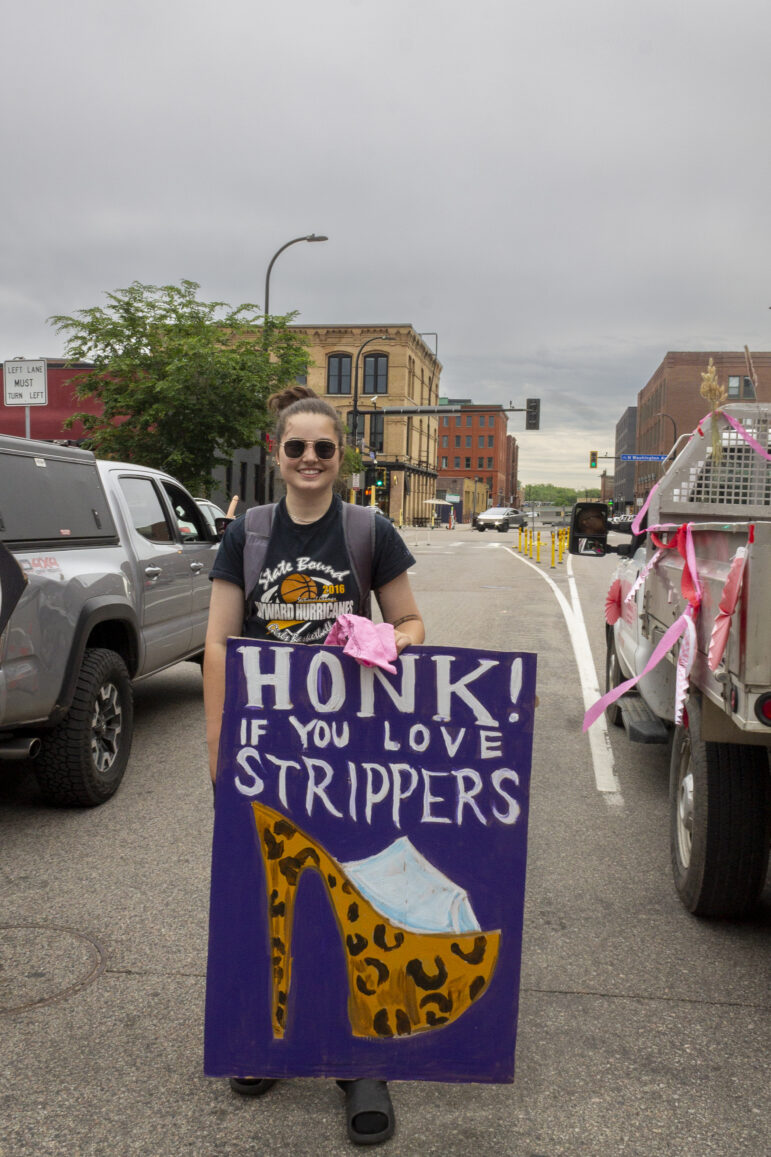 A marcher holds a sign that reads, “Honk! If you love strippers” with a high heeled, leopard pleaser shoe drawn on. Many cars passing by showed their support for the parade. 