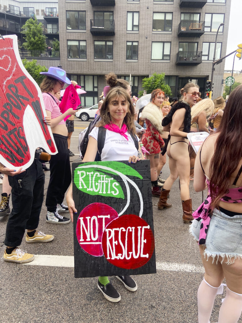 A marcher’s sign reads “Rights, not rescue” over an illustration of a cherry. Attendees emphasized the needs for worker protections, rather than outsiders swooping in to “save” them or push them to leave the profession. 