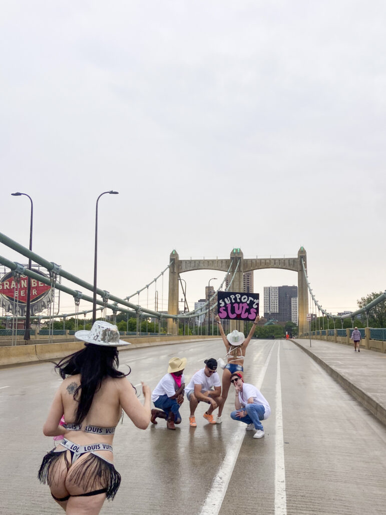 A protest sign reads “Support Sluts” while the parade made its way across Father Hennepin Bridge. Many allies, including the spouses and family members of sex workers, were in attendance to show support for their loved ones. 