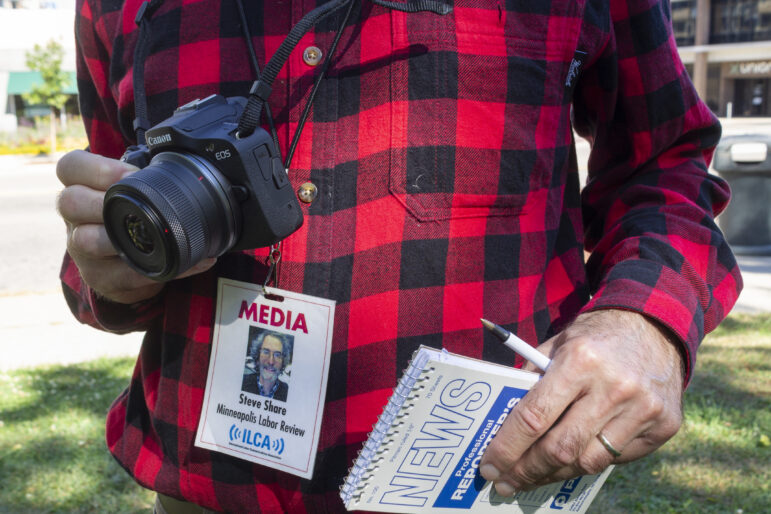 Steve Share, editor of the 'Minneapolis Labor Review' with his notebook, camera, and press badge.