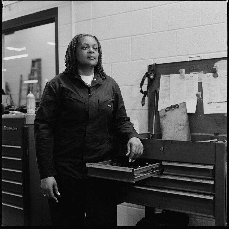 Kira Ross is a member of ATU Local 1005 and Metro Transit’s first black woman mechanic. Ross is photographed while working at the Haywood Garage in Minneapolis, posing next to a tool box. 