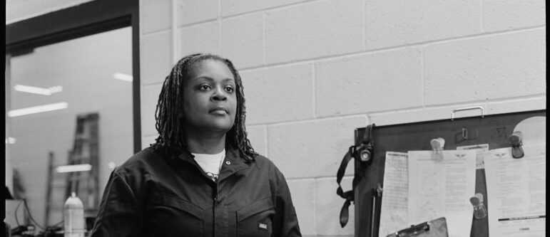 Kira Ross is a member of ATU Local 1005 and Metro Transit’s first black woman mechanic. Ross is photographed while working at the Haywood Garage in Minneapolis, posing next to a tool box. 