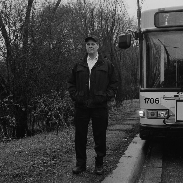 Todd Eddy, a 20-year veteran bus driver and ATU Local 1005 union member, poses for a photograph at a beloved rest stop off the 7 bus, surrounded by the forest of Theodore Wirth Park in Minneapolis. 
 
