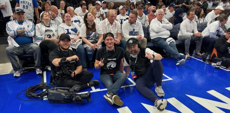 Workers from the Minnesota Timberwolves and Lynx in-house audio visual crew pose for a photo court side.