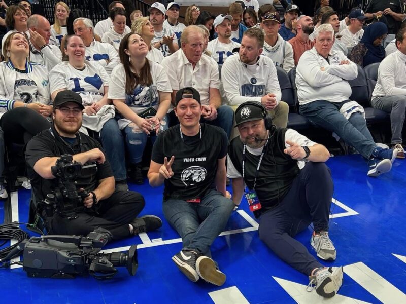 Workers from the Minnesota Timberwolves and Lynx in-house audio visual crew pose for a photo court side.