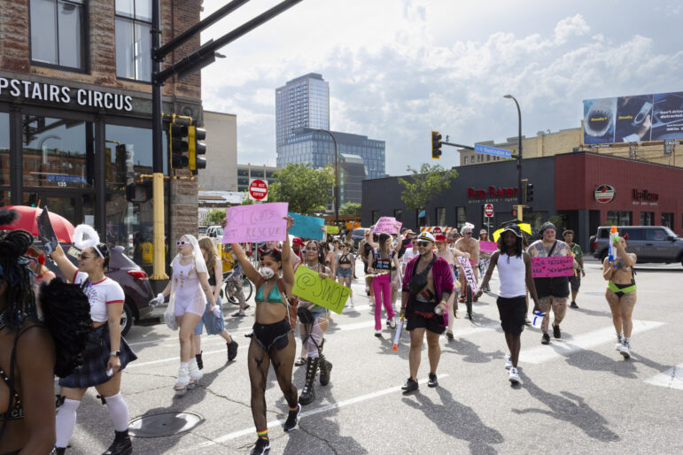 The march as it turned onto Washington Avenue in downtown Minneapolis. One sign in pink reads, “Rights not rescue”.