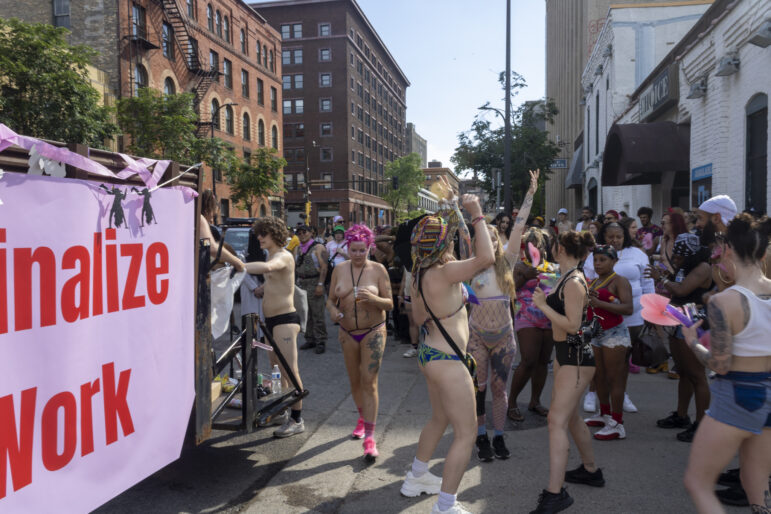Parade-goers dance before the start of the procession through downtown Minneapolis. Andi Snow, executive director of SWOP MPLS stands in the center with pink hair.